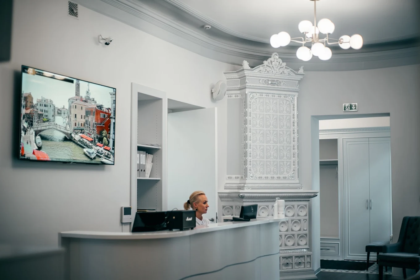Reception area with historic tile stove and chandelier